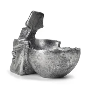 Detailansicht eines silbernen Totenkopf-Brillenhalters und kreativen Harzschalen.