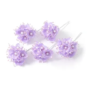 Detaillierte Nahaufnahme von fünf violetten Kunstblumensträußen mit Perlen für Hochzeiten
