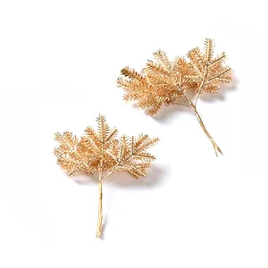 Detailaufnahme von goldenen künstlichen Weihnachtskiefernzweigen mit Glitzer-Finish