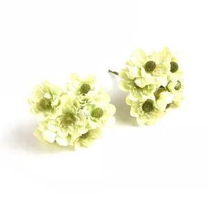 Nahaufnahme von hellgrünen künstlichen Gänseblümchen-Seidenblumen mit Samtmitte und Drahtstiel