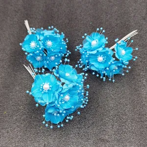 Makro-Detail von drei mini blauen Kunstblumen-Clustern mit eleganten Kunstperlen