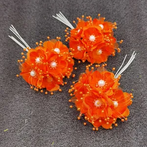 Detailansicht von orangen künstlichen Hochzeitsblumen mit Perlen und Perlensprays