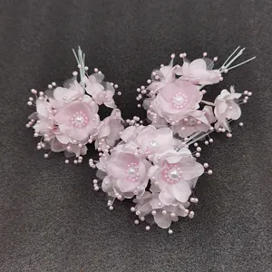 Detailansicht von rosa Kunstblumen mit Perlenzentren für Brautaccessoires
