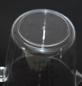 Detailed macro view of clear plastic measuring cup showing embossed measurement scales