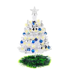 Miniatur-Weihnachtsbaum in Weiß für den Tisch mit blauem Schmuck und warmem Licht