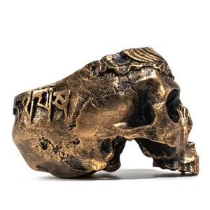 Vista dettagliata del teschio in resina bronzo antico con scritte tibetane incise.