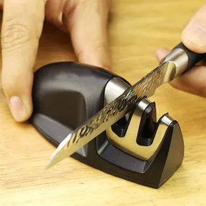 Primer plano de un afilador de cuchillos manual portátil de 2 etapas afilando una hoja de acero