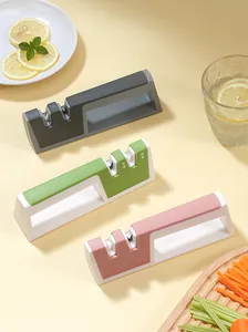 Three colorful manual kitchen knife sharpeners displayed with fresh lemon and sliced vegetables