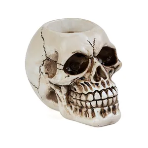 Close-up of realistic resin skull candle holder with weathered bone texture detail.