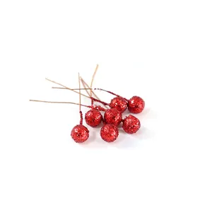 Macro view of artificial red glitter berries with wire stems for Christmas DIY decor.