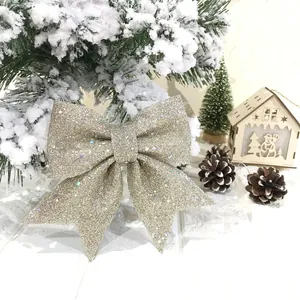 Detailansicht einer glitzernden champagnerfarbenen Weihnachtsschleife in einer festlichen Schneekulisse