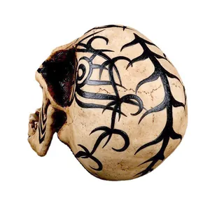 Macro view showing intricate tribal tattoo patterns on a decorative resin skull ornament.