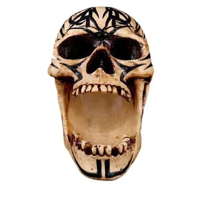Close-up detail of resin skull ornament with intricate black tribal pattern carvings