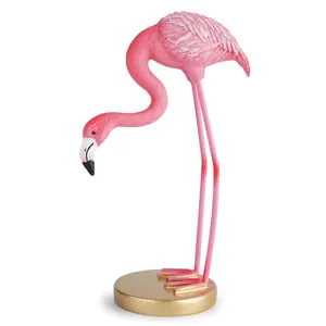 Vue détaillée d'une élégante figurine de flamant rose sur un socle doré décoratif