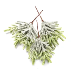 Macro view of artificial pine branches featuring realistic snow flocking texture.