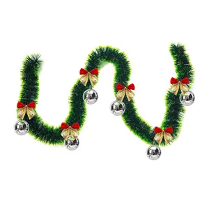 Detailed view of 2 meter Christmas green tinsel garland with red bows and silver balls