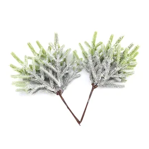 Detail view of artificial pine branches with realistic white snowy frost texture
