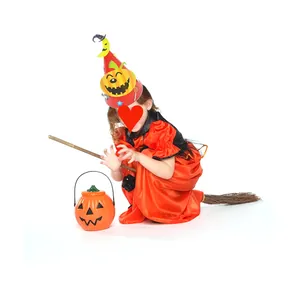 Child wearing a Halloween DIY paper hat with pumpkin bucket and broomstick props