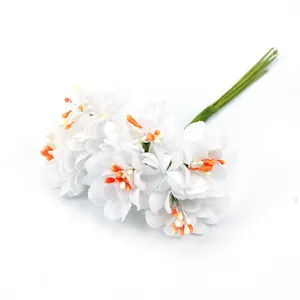 Nahaufnahme künstlicher weißer Seiden-Chrysanthemen mit leuchtend orangefarbenen Staubblättern.