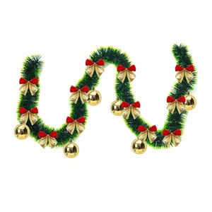 Detailed view of 2m green Christmas tinsel garland with festive gold bows and ball ornaments