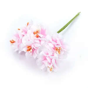 Detailaufnahme eines rosa-weißen Seiden-Chrysanthemenstraußes mit orangefarbenen Staubgefäßen