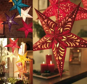 Detail of laser-cut paper star lanterns with warm glow for festive ceiling decor
