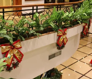 Grandi fiocchi di Natale oro e rossi che decorano una ringhiera interna