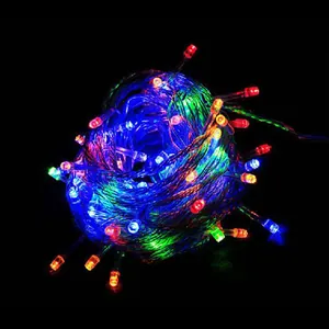 Close-up of colorful LED Christmas string lights glowing intensely in a dark room setting.