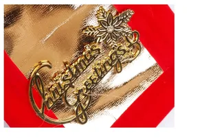 Primo piano dettagliato di una targa decorativa dorata Christmas Greetings con fiocco