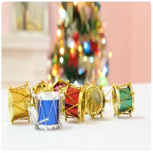 Macro shot of colorful laser Christmas drum ornaments with festive tree bokeh