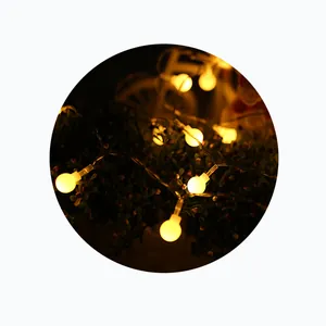 Close-up of frosted globe LED string lights with warm glow for festive garden decor