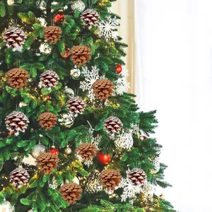 Detail showing natural and snow-dusted pine cone ornaments hanging on a Christmas tree