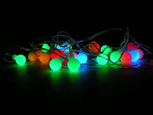 Close-up of vibrant frosted LED ball string lights glowing against a dark backdrop