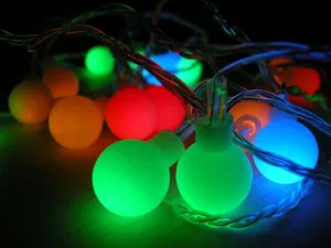 Macro detail of glowing multi-color frosted ball LED Christmas decoration string lights