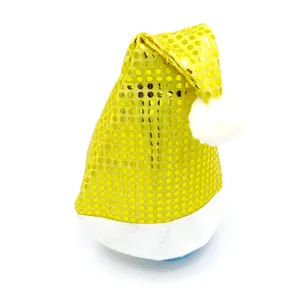 Detail van een gele kerstmuts met pailletten, witte pluche rand en pompon.