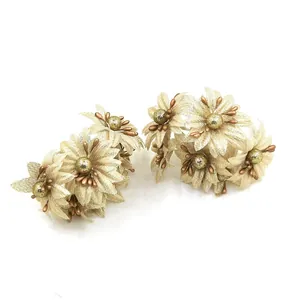 Nahaufnahme goldener Kunstblumen aus Stoff für DIY-Haarschmuck und Dekorationen