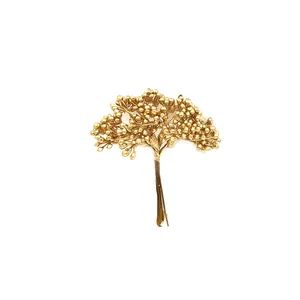 Detailaufnahme eines goldenen künstlichen Beerenstraußes für DIY-Floristikhandwerk