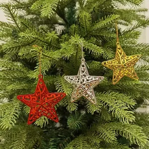 Red, silver, and gold hollow-out star ornaments hanging on a green Christmas tree