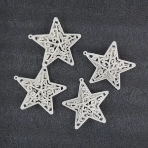 Detailed view of four white hollowed-out star Christmas ornaments on a dark background.