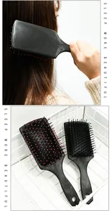 Detail view of black hair paddle brush with massage pins, perfect for tangle-free styling.