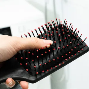 Black paddle hair brush with red tips and air cushion for scalp massage and untangling hair.