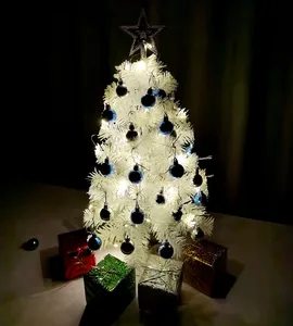 Mini witte kerstboom versierd met blauwe ornamenten en warme LED-lampjes