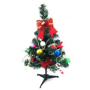 Decorated mini tabletop artificial Christmas tree with red bows and colorful ornaments