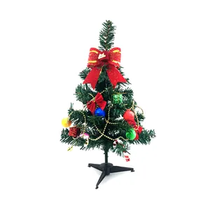 Close-up view of a small decorated tabletop Christmas tree with red bows and colorful ornaments