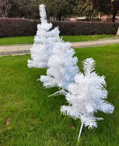 Set of three miniature white Christmas trees in varying sizes displayed on a green lawn