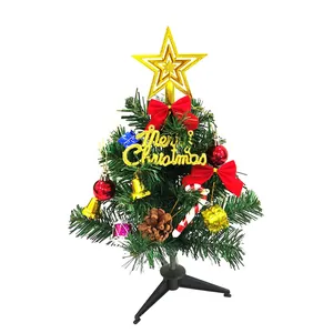 Primo piano di un albero di Natale da tavolo da 30 cm con ornamenti e puntale a stella d'oro