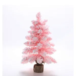 Vue détaillée d'un mini sapin de Noël rose floqué avec une base en toile de jute