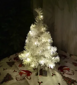 Detailed view of a tabletop white Christmas tree featuring warm white LED fairy lights