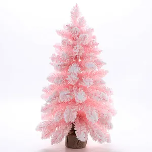 Détail d'un sapin de Noël rose floqué avec une texture de neige sur les branches