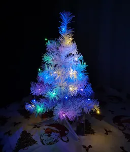 Mini white tabletop Christmas tree decorated with colorful LED lights for holiday